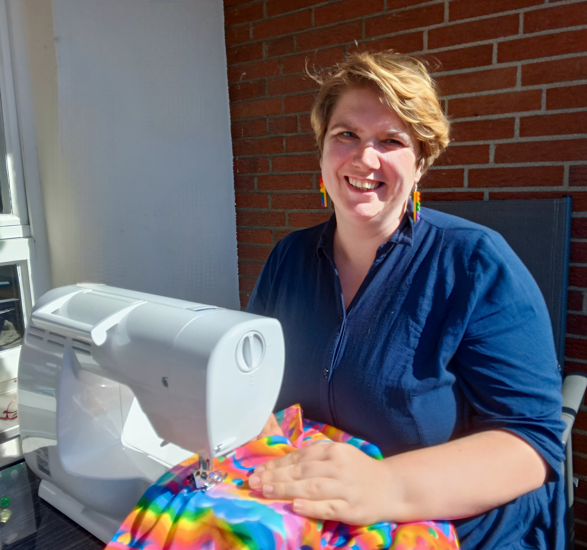 Portraitbild Nicole an der Nähmaschine sitzend.